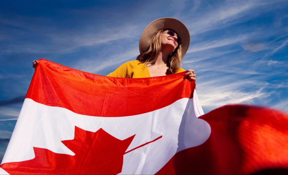 a photograph of a woman holding a canadian flag 2961063 1 scaled e1592581146783