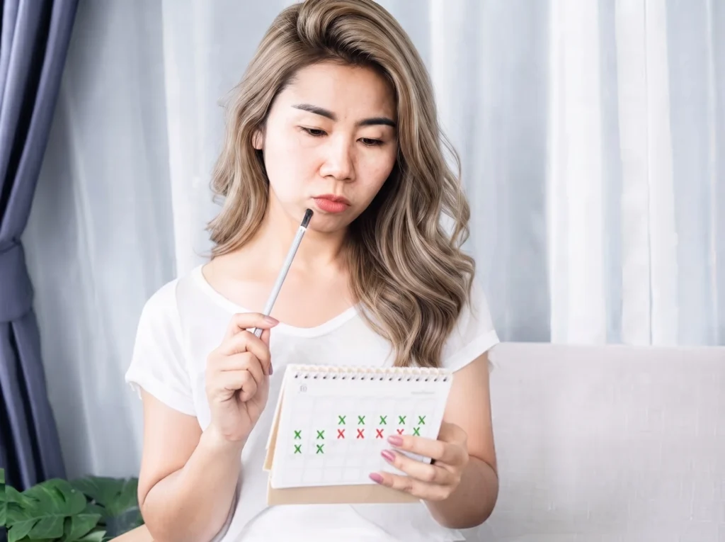 Woman looking at calendar tracking 202607281818